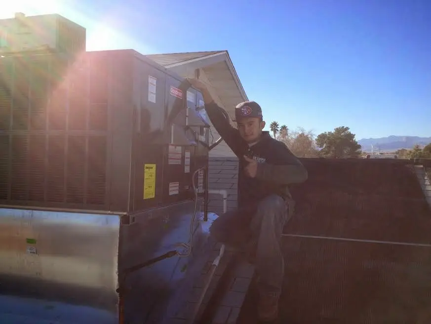HVAC technician performing Boiler Repair on a rooftop unit in Millsboro